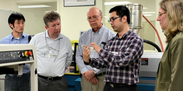 Three CPES researchers talk animatedly at a conference 